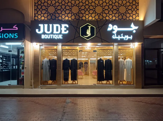 Dimensional illuminated letters for Jude Boutique on a geometric facade.