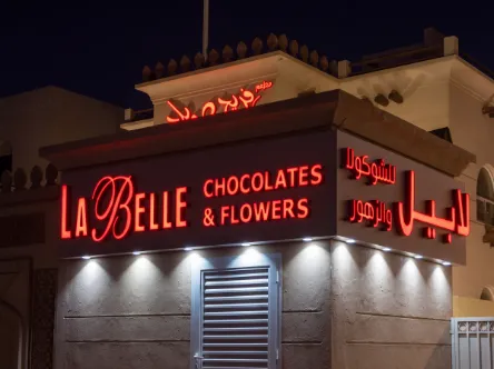Distinctive red front-lit lettering and Arabic script for La Belle Chocolates and Flowers.