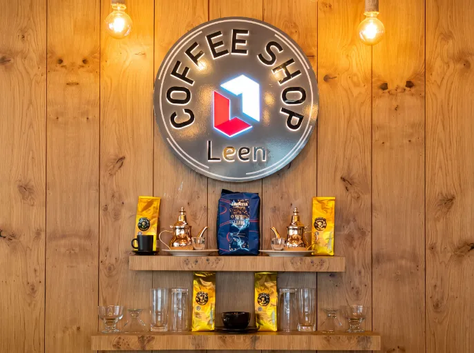 Circular front-lit logo sign for Leen Coffee Shop mounted on a wooden wall.