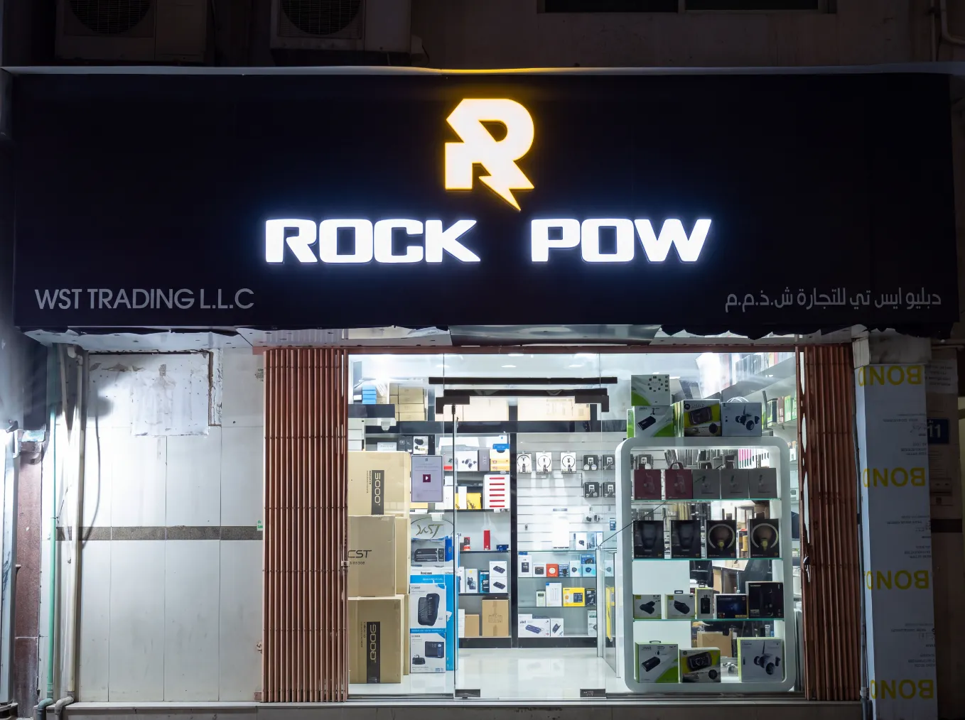 Illuminated white acrylic channel letters for Rock Pow on a black storefront